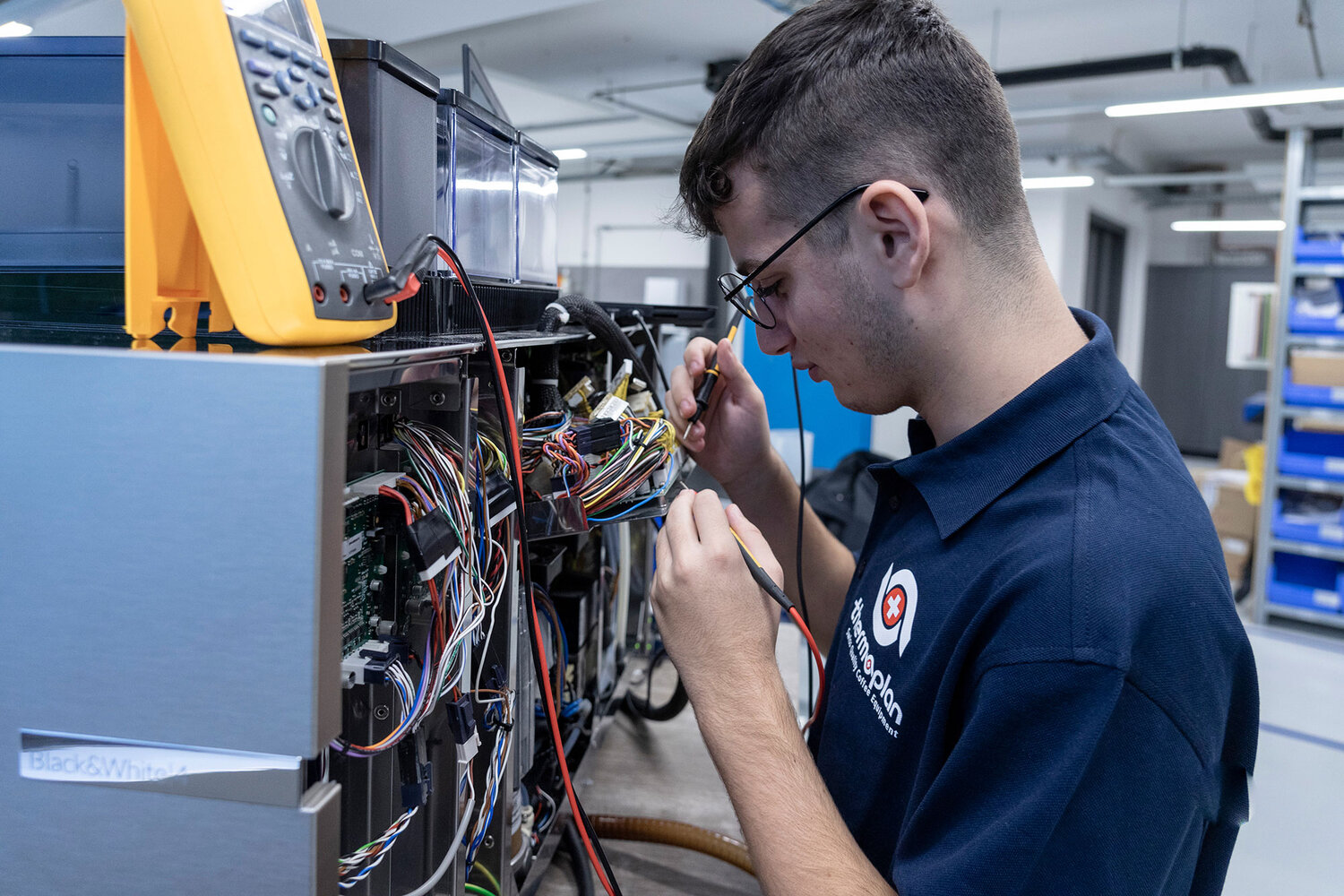 Apprentice automation technician soldering on a coffee machine