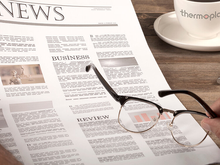 Newspaper with coffee and glasses on wooden table